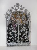 A contemporary metal floral 'window' mirror having opening 'shutters'.