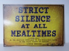 A metal sign 'strict silence at all mealtimes'.