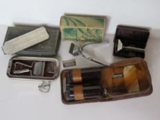 A vintage gents vanity case together with two vintage razors, an eye glass and a pair of clippers.