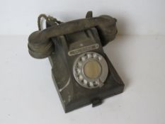 A vintage GPO telephone in black 'Call Exchange' plaque to front.