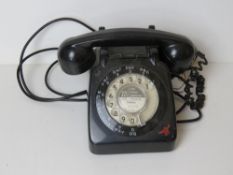 A vintage black plastic rotary telephone