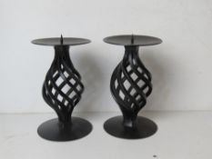 A pair of black painted metal candlesticks.