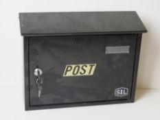 A black metal post box with keys.