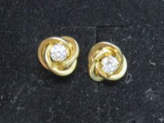 A pair of yellow metal white stone stud earrings.