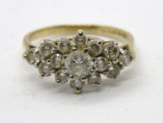 A 9ct gold cluster ring having central white stone cluster with trio of white stones to each