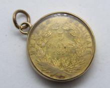 An 1859 Napoleon III 5 francs coin in 9ct gold glazed frame (glass a/f), stamped 9ct to frame,