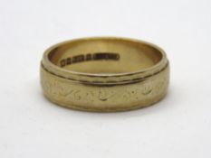A 9ct gold ring having floral engraving to the central band, hallmarked 375, size L, 3.5g.
