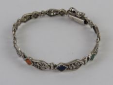 A South American silver bracelet having hinged panels featuring Llamas upon and set with hard
