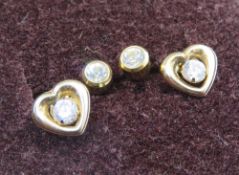 Two pairs of yellow metal stud earrings, one pair in the form of hearts.