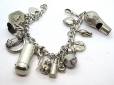A HM silver watch guard chain converted to use as a charm bracelet having various charms upon