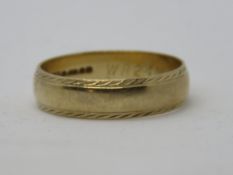 A 9ct gold ring, hallmarked 375, having engraved patterned borders, size W, 4.1g.