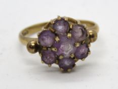 A 9ct gold and amethyst floral cluster ring, seven round cut amethysts all claw set, hallmarked 375,