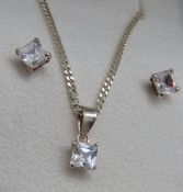 A silver suite comprising pendant on chain and stud earrings all having square shaped white stone,
