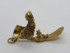 A 9ct gold charm in the form of a boot, hallmarked 375, opening to reveal man and dog within,