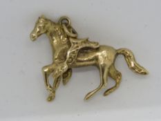A 9ct gold pendant in the form of a horse with saddle upon, hallmarked 375, approx 3cm wide, 6.3g.