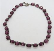 An amethyst paste graduated stone collar style necklace, white metal, approx 42cm in length.