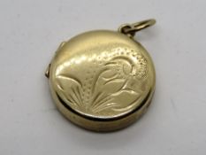 A 9ct gold round locket having floral engraving to front, hallmarked 375, 2.2g.
