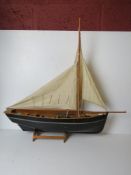 A model fishing vessel on stand measurin