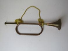 A brass and copper bugle with silken cor