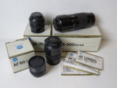 Four Minolta camera lenses, three having