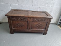 An oak coffer bach chest having carved panels to front and measuring 108 x 49.5 x 55cm.