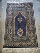 A woollen rug in blue ground with floral pattern approx. 150 x 95cm.