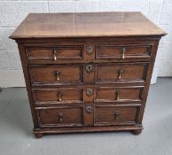 An oak chest of two over three graduated drawers having bun feet,