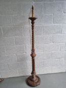 A carved wooden standard lamp base having reeded and twisted design.