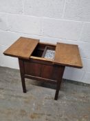An Oak workbox raised over square shaped legs,
