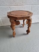A low octagonal planter table having carved elephant legs with bone tusks measuring approx.
