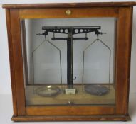 A set of balance scales in glazed case by Philip Harris Ltd Birmingham.
