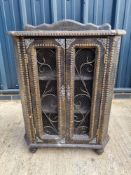An unusual faux crocodile leather and ironwork cabinet.
