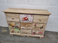 A contemporary apothecary style low cabinet having botanical themed drawers measuring approx.