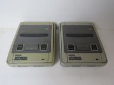 Two Nintendo Super Nintendo Entertainment Systems, no cables.