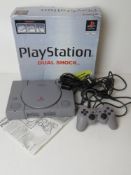 A Playstation 1 in original box with controller and cable.