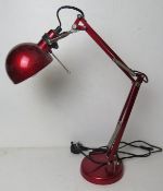 A red painted metal contemporary angle poise table lamp.
