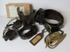 A set of brown leather belts, stirrups,