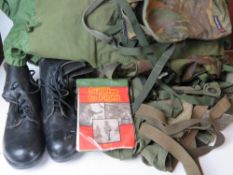 A Berghaus camouflage military rucksack containing a large quantity of kit inc black leather boots,