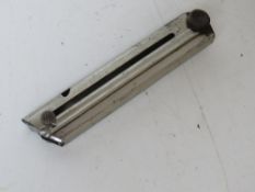 A WWI German Luger Magazine, serial number 70447 on wooden base.