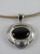 An hallmark silver pendant set with mother of pearl and onyz on a 925 silver chain.