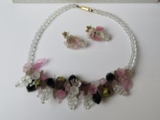 A floral contemporary beaded necklace with matching earrings in Daisy Chain of Cambridge England