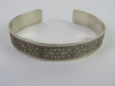 A HM silver bangle having carved foliate pattern upon,
