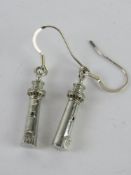 A pair of earrings in the form of lighthouses.