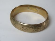A 9ct gold plated hinged bangle having engraved fleur de lis pattern. Approx 6 x 5.
