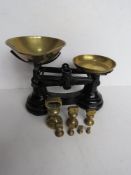 An English made black painted set of balance weights having brass bowls and weights.