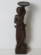 A carved wooden female figure tealight holder.