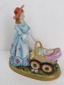 A Dresden Porcelain figurine of a lady pushing a pram, arm a/f, hand painted and gilded throughout,