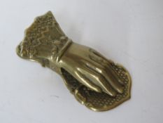 A brass desktop paper weight clip in the form of a ladies hand.