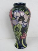 A slender vase by Moorcroft, having impressed back stamp and dated 2002, standing approx 21cm high.