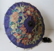 A vintage paper parasol together with a fur purse.